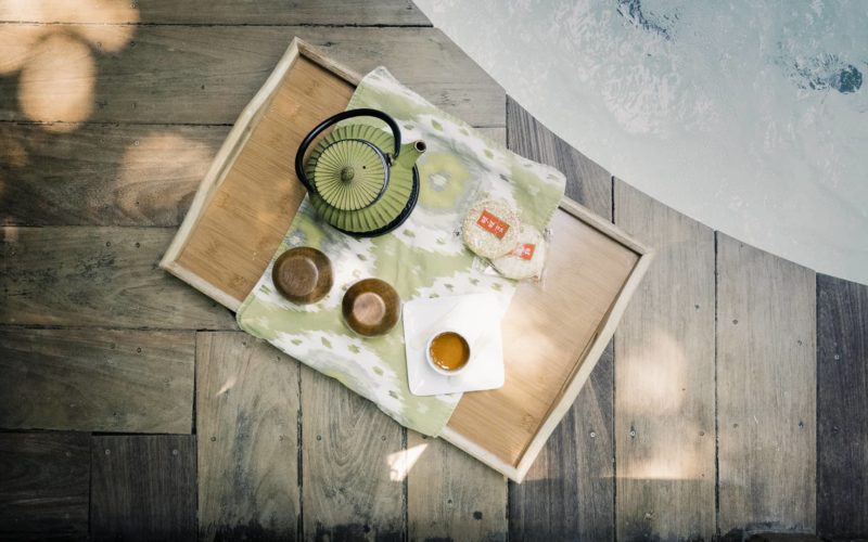 an aerial shot of a serving tray with tea and snacks next to a hot tub